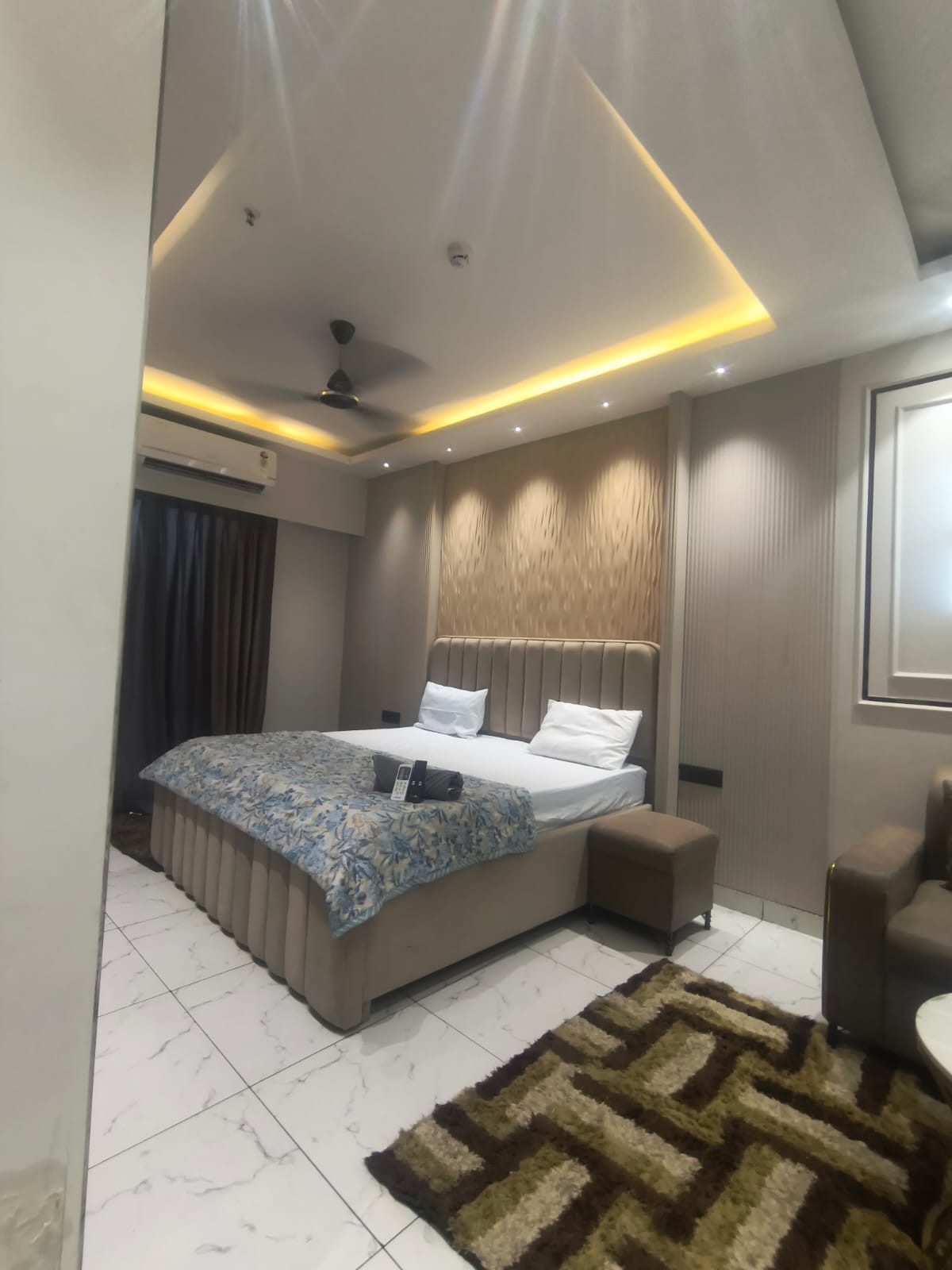 Double bedroom with a padded headboard and recessed ceiling lighting