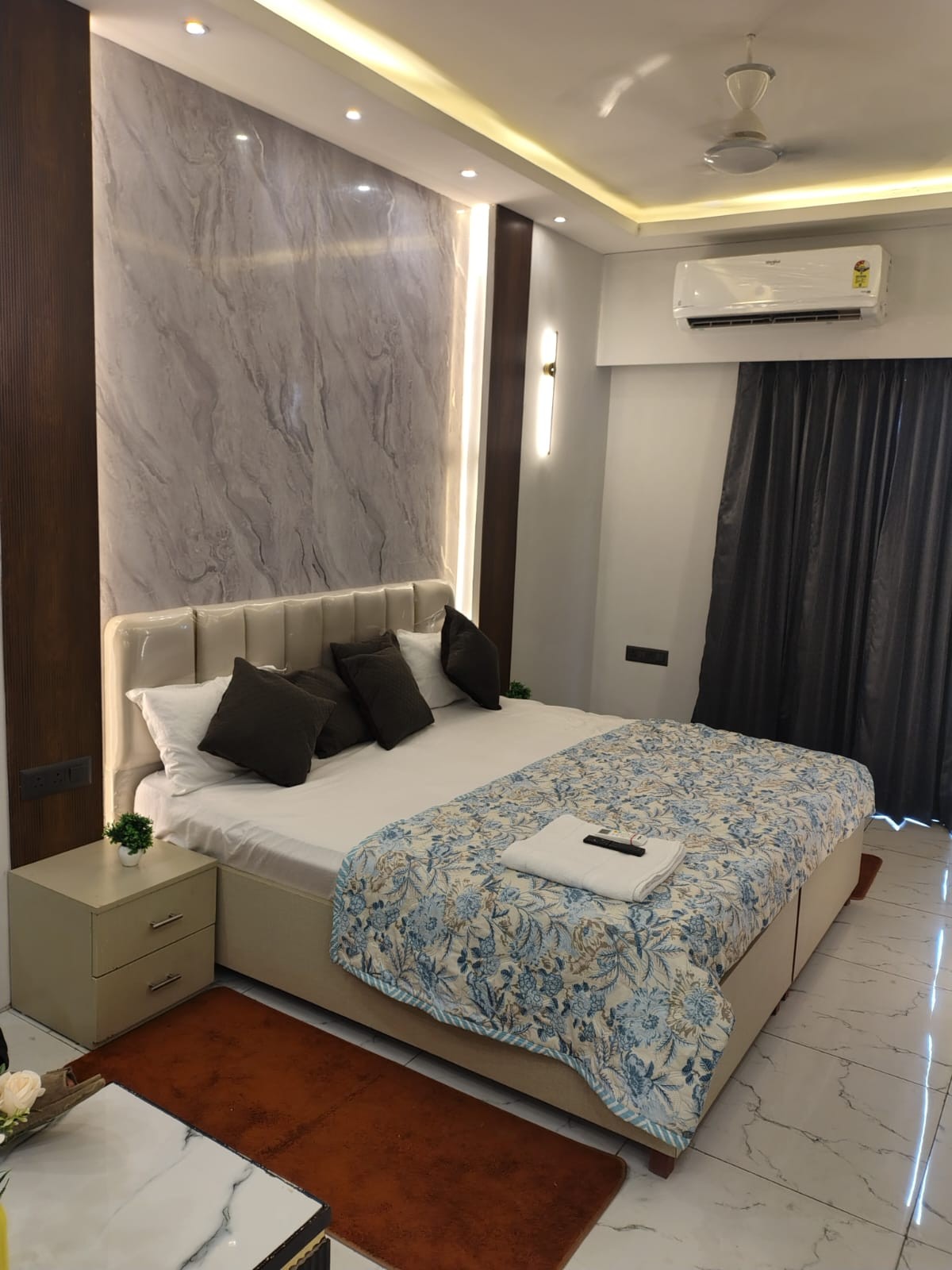 Double bed with a padded feature wall and bedside lamps