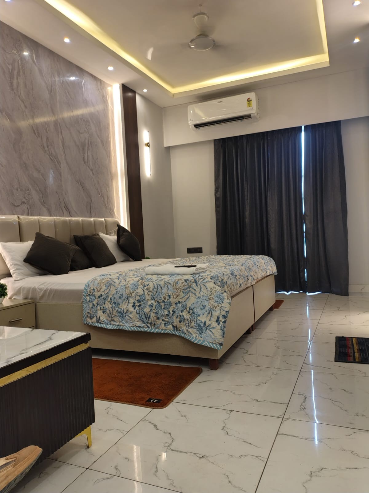Bedroom with patterned bedding, air conditioning and tiled flooring