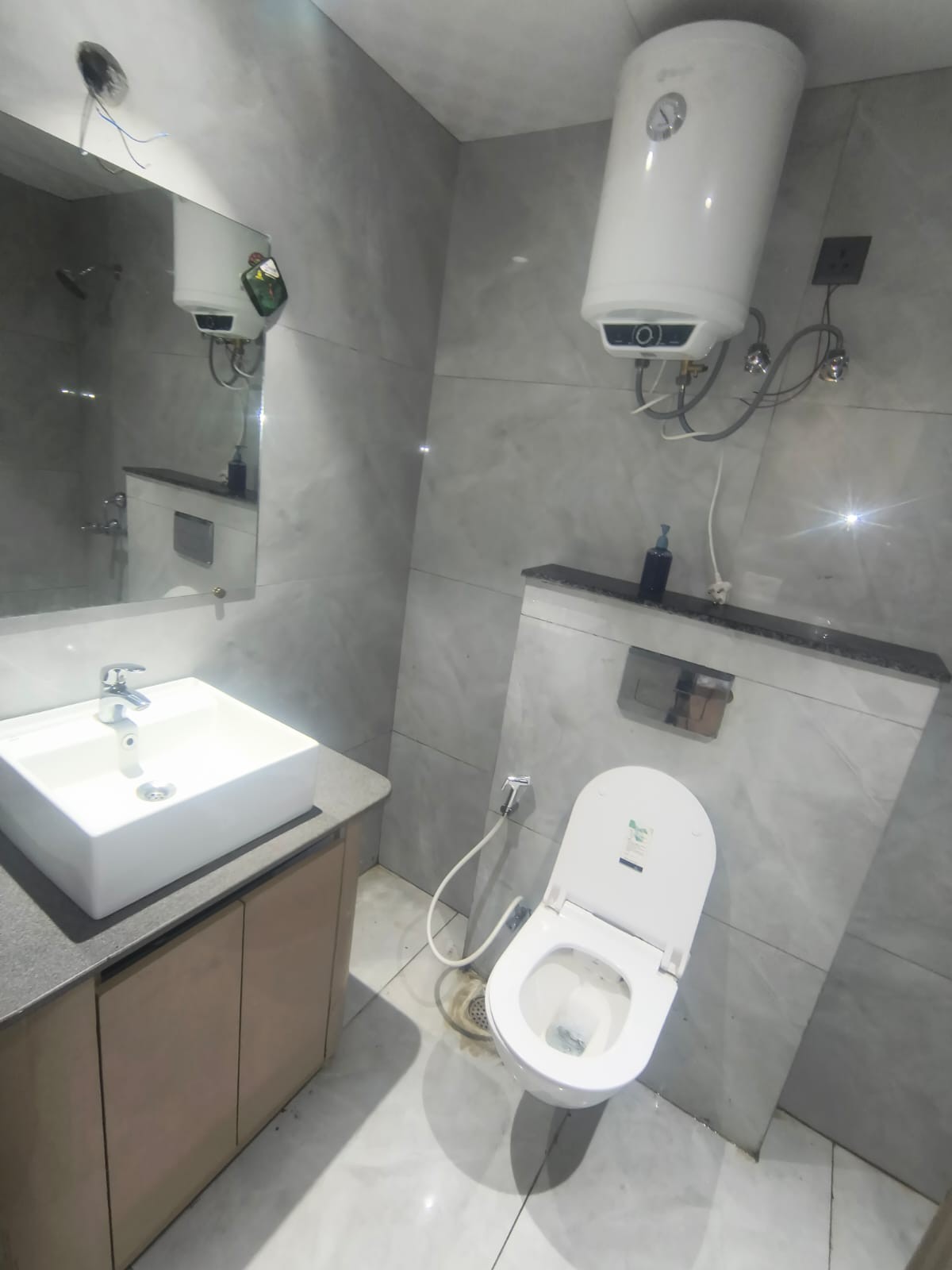Bathroom with a basin, toilet, wall-mounted mirror and water heater